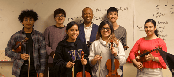 A group of students with violins in their hands.